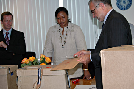 Prosecutor Luis Moreno Ocampo opens the sealed envelope with a list of names in his Office in The Hague